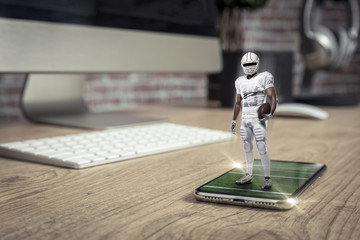 Football Player with a white uniform playing and coming out of a full screen phone on a wooden...