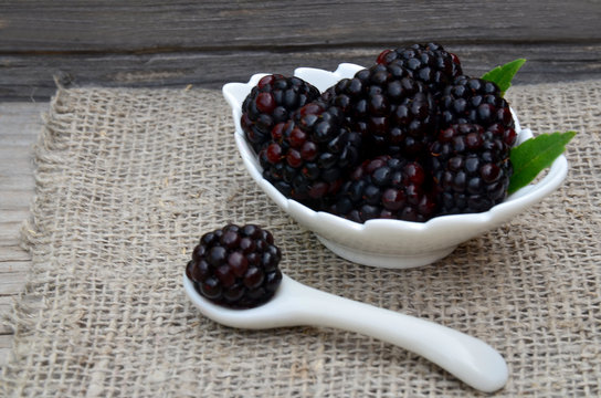 Freshly picked organic blackberries in a white bowl on old wooden table.Healthy eating,
vegan food or diet concept.Selective focus.
