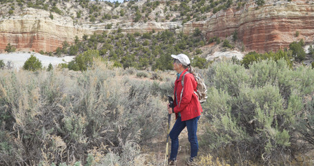 Retired Caucasian woman hiking through dry vegetation in Zion Utah