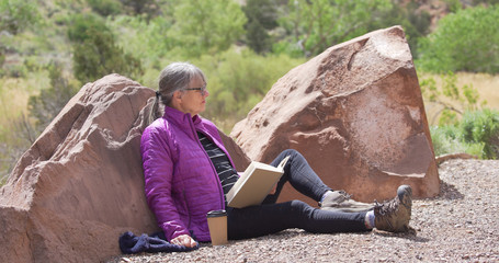 Portrait of healthy senior woman having time to herself to read outdoors