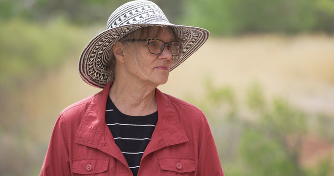 Somber Senior Woman Thinking Quietly Outdoors In The Sun