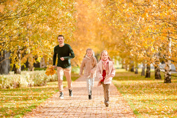 Fototapeta premium Family of dad and kids on beautiful autumn day in the park