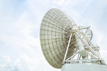 large white satellite dishes turn up skyward on blue sky in communication antenna system center station