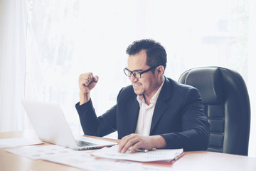 business man celebrating happy winner, get the good news on office desk  , business success concept