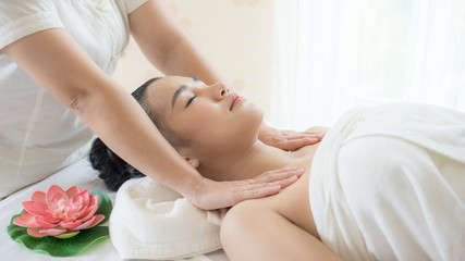 Obraz na płótnie Canvas Beautiful and healthy young woman relaxing with face and shoulder massage at beauty spa salon