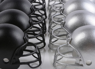 Black and Silver American Football helmets lined up facing each other