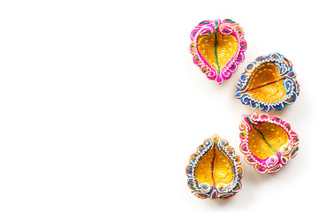 Happy Diwali - Clay Diya lamps lit during Dipavali, Hindu festival of lights celebration. Colorful traditional oil lamp diya on white background
