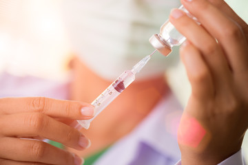 Female doctor with a stethoscope on shoulder holding syringe and vaccine. Healthcare And Medical concept.