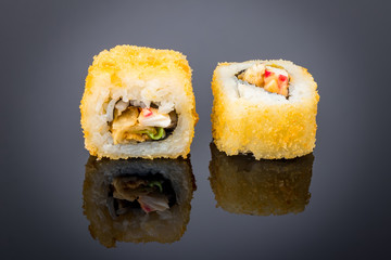 Hot roll with tempura crab on black with reflection