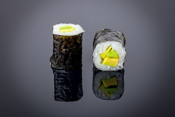 avocado roll on black background with reflection