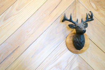 Deer metal casting on a wooden wall in the house. To use in decoration
