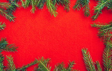bright christmas background frame with a copy space with  fir branches with a red texture