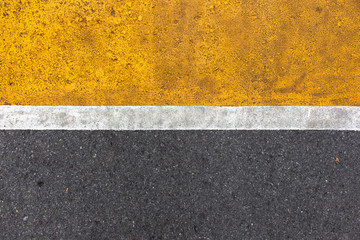 Background of yellow black strips . Dark grey asphalt road divided by yellow paint. yellow black background