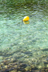 Fototapeta na wymiar Yellow fishing buoy floating in Mediterranean sea