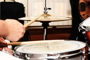 A closeup of a drummer playing a snare drum and high-hat.