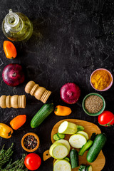 Vegetarian food concept. Set of vegetables for stew. Squash, bell pepper, tomato, spices, oil on black background top view space for text