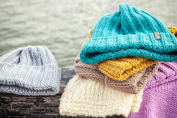 Beautiful background knitting winter blue and yellow a lot hat. Crochet hook handmade. Close-up of knitted hats of blue, yellow, pink and white