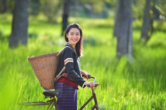 Traditional Hmong girl with basket of agricultural crops walking with bicycles in forest Happy Hmong girl smiling with green nature in Sapa city, northern Vietnam