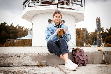 Close-up of woman hands knitting  green  wool hat  against the background of the old lighthouse  in...