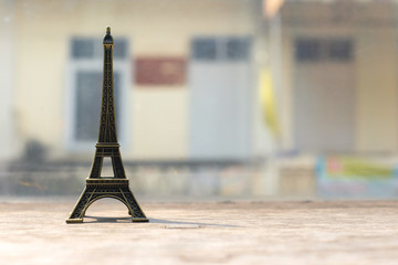 Eiffel tower miniature on concrete table with blurred background