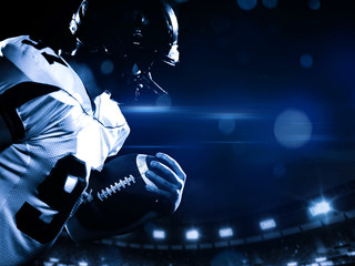 American football player holding ball while running on field