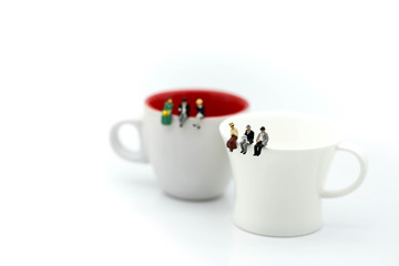 Miniature people : People sitting on cup using for concept of Native American Day.