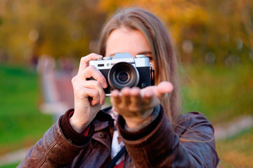 Young woman making photo of sunset sun on the pulm.