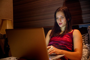 woman work with a laptop at home on the bed in the evening - 222251459