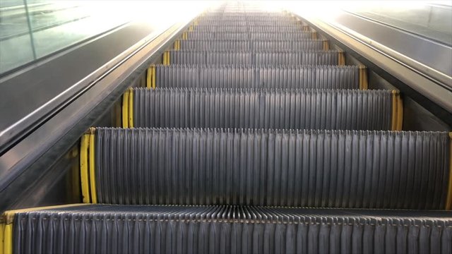 Escalator going up, low moving perspective cut to glowing white transition.