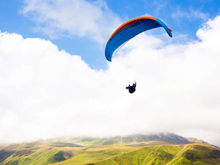 Paragliders flying with a paramotors with beautiful mountain view against blue cloudy sky