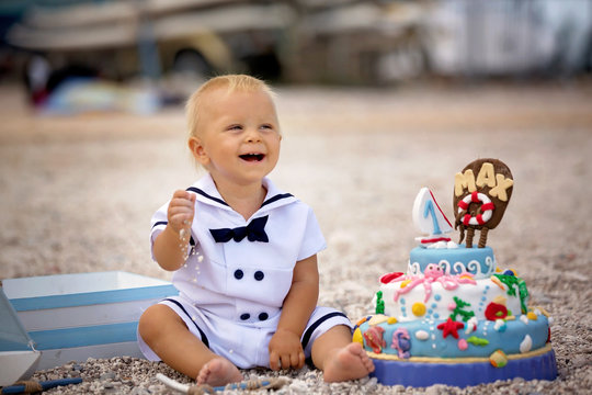 Sweet baby boy, celebrating on the beach first birthday with sea theme cake and decoration