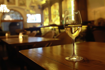 glass of white wine in the restaurant / white wine in the interior of the restaurant a table with...