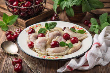 dumplings with cherry (Vareniki, pierogi), rustic background