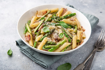 asparagus and bacon penne pasta with parmesan cheese in white bowl