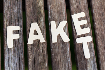 Fake, fact, as text, letters on wood