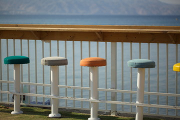 colorful chairs near the wooden bar with a view of the sea in Eilat Israel