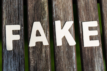 Fake, fact, as text, letters on wood