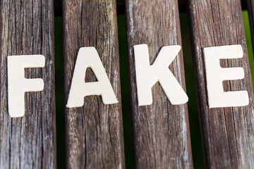 Fake, fact, as text, letters on wood