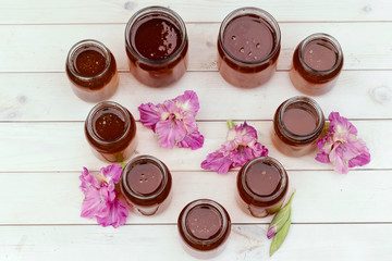 Fresh honey in glass jar on light white wooden background.