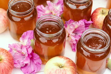 Fresh honey in glass jar on light white wooden background.