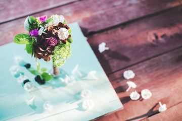 A small bouquet of wild flowers in a vase on a mint and Burgundy background on a summer day in the garden.