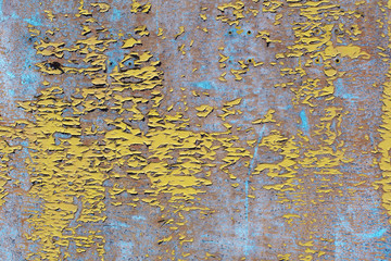 Peeling yellow and blue paint on a concrete stone slab.Texture