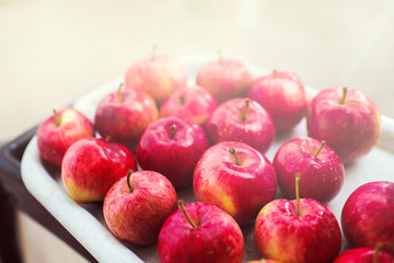 Ripe red apples on a tray in the garden on a summer day. Autumn harvest