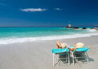 Couple on sunbeds relaxing at the beach in Lefkada