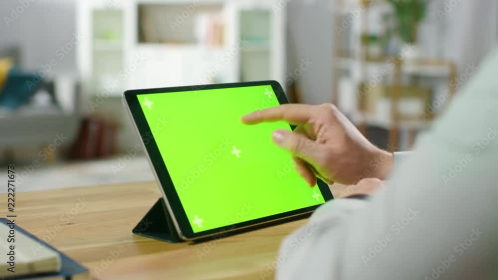 Poster first person shot of a man using hand gestures on green mock-up screen digital tablet computer in la