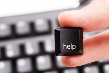 Holding Help Key With Fingers With Keyboard In Background