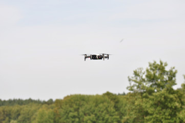 Eine Drohne im Anflug / Eine kleine fliegende Drohne mit Kamera macht Life Videos in der Luft