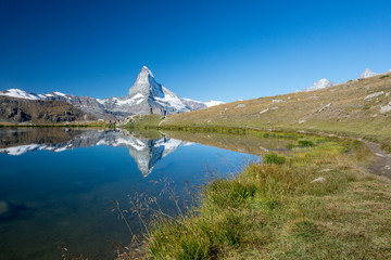 Bergsee oberhalb Zermatt mit sich spiegelndem Matterhorn