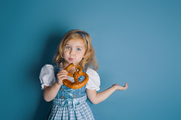 Little  girl in traditional german dress dirndl eating bretzel.Oktoberfest - 222273809