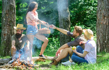 Friends relaxing near bonfire. Friends enjoy vacation or leisure nature forest background. Plan for perfect day hike picnic. Pleasant hike picnic in forest. Company friends or family relaxing picnic